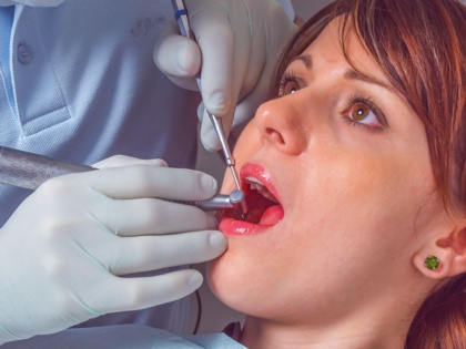 Zahnarzt mit Patientin, bohren und behandeln eines kranken Zahnes