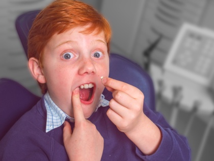 Kind-Zahn-entfernt-auf-Behandlungstuhl-rote-Haare